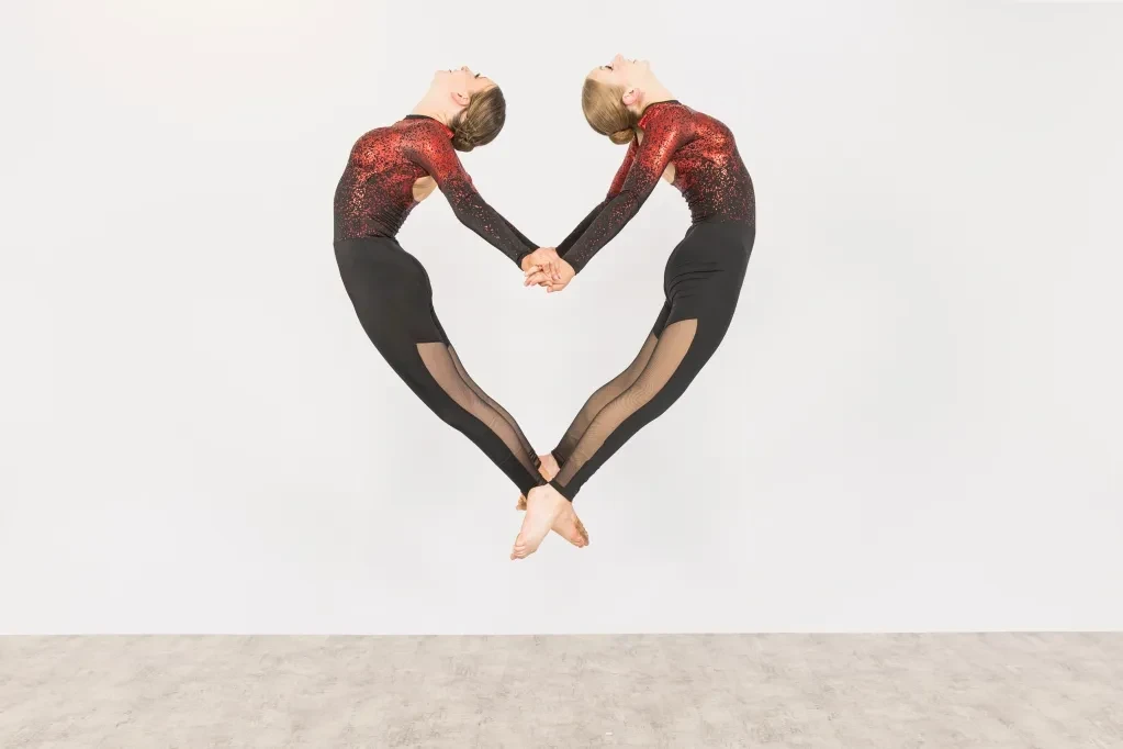 Two dancers forming a heart shape mid-air
